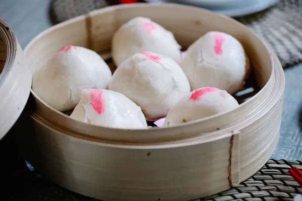 Steamed BBQ pork buns in a bamboo steamer