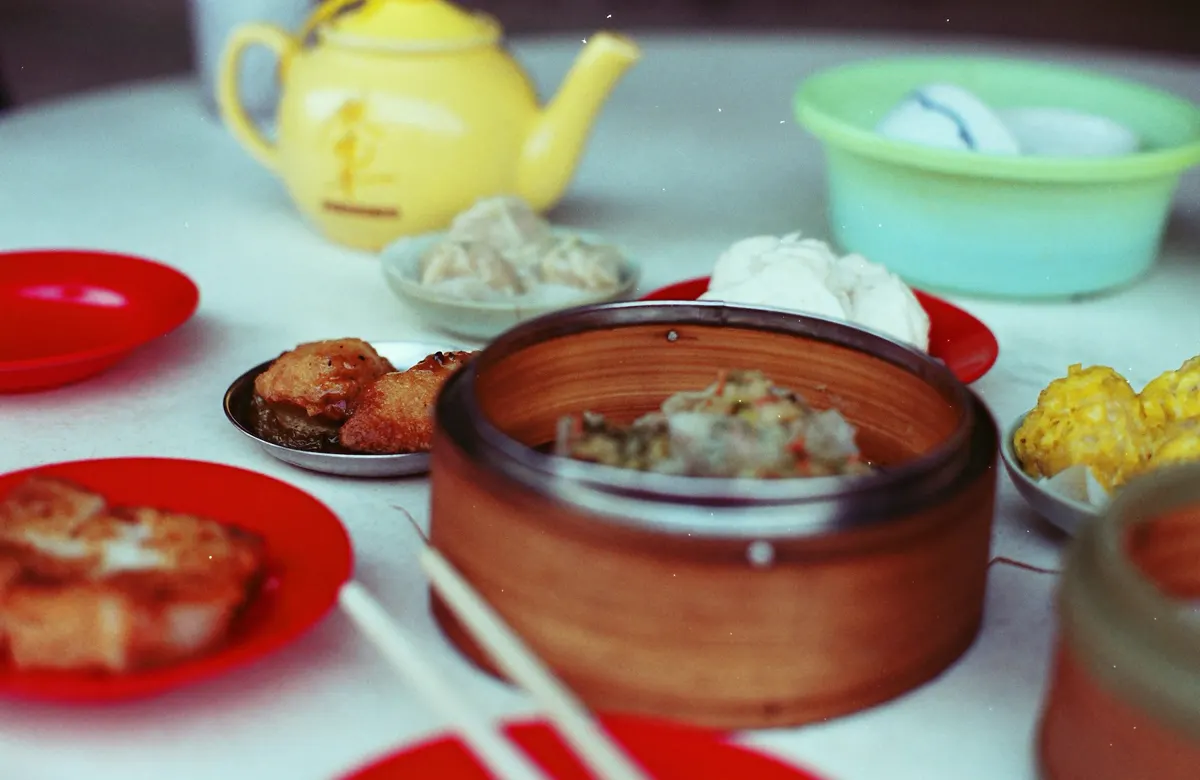 A table of dim sum dishes, dumplings and tea